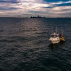Freeboard technician deploying smart buoy in Lake Erie near Cleveland, Ohio to monitor water quality.