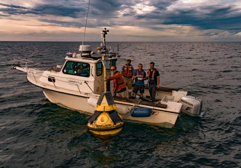 Freeboard personnel deploying a smart buoy from LimnoTech's boat in Lake Erie.